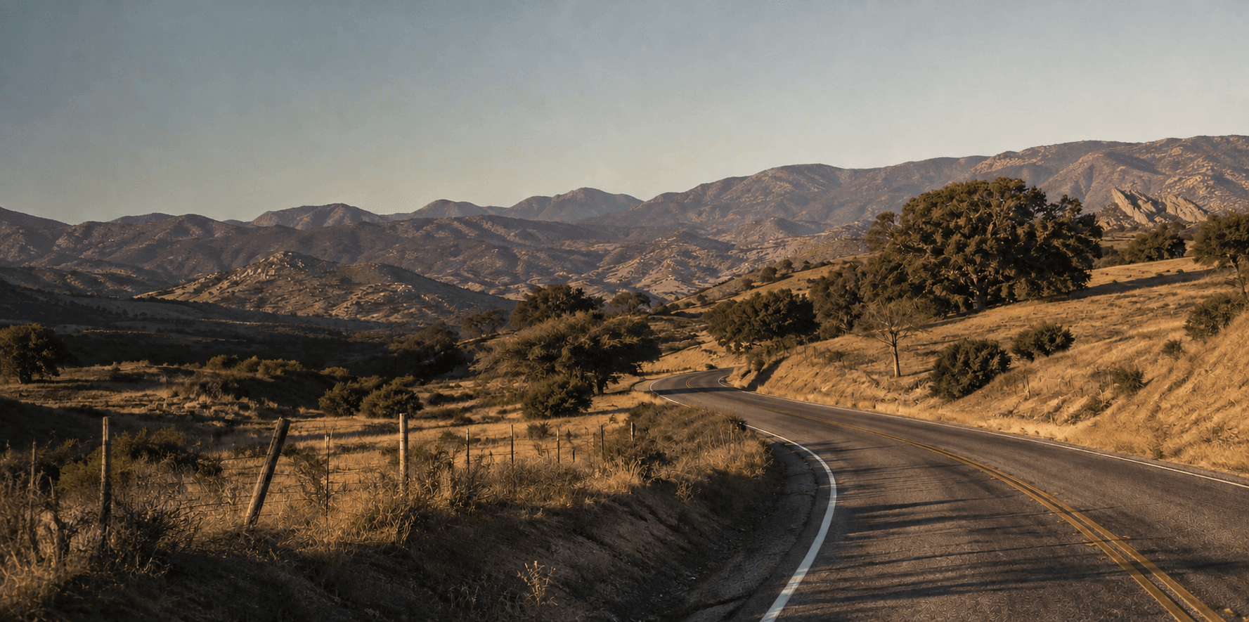 A rural road winding through Acton's golden foothills with Vasquez Rocks in the distance