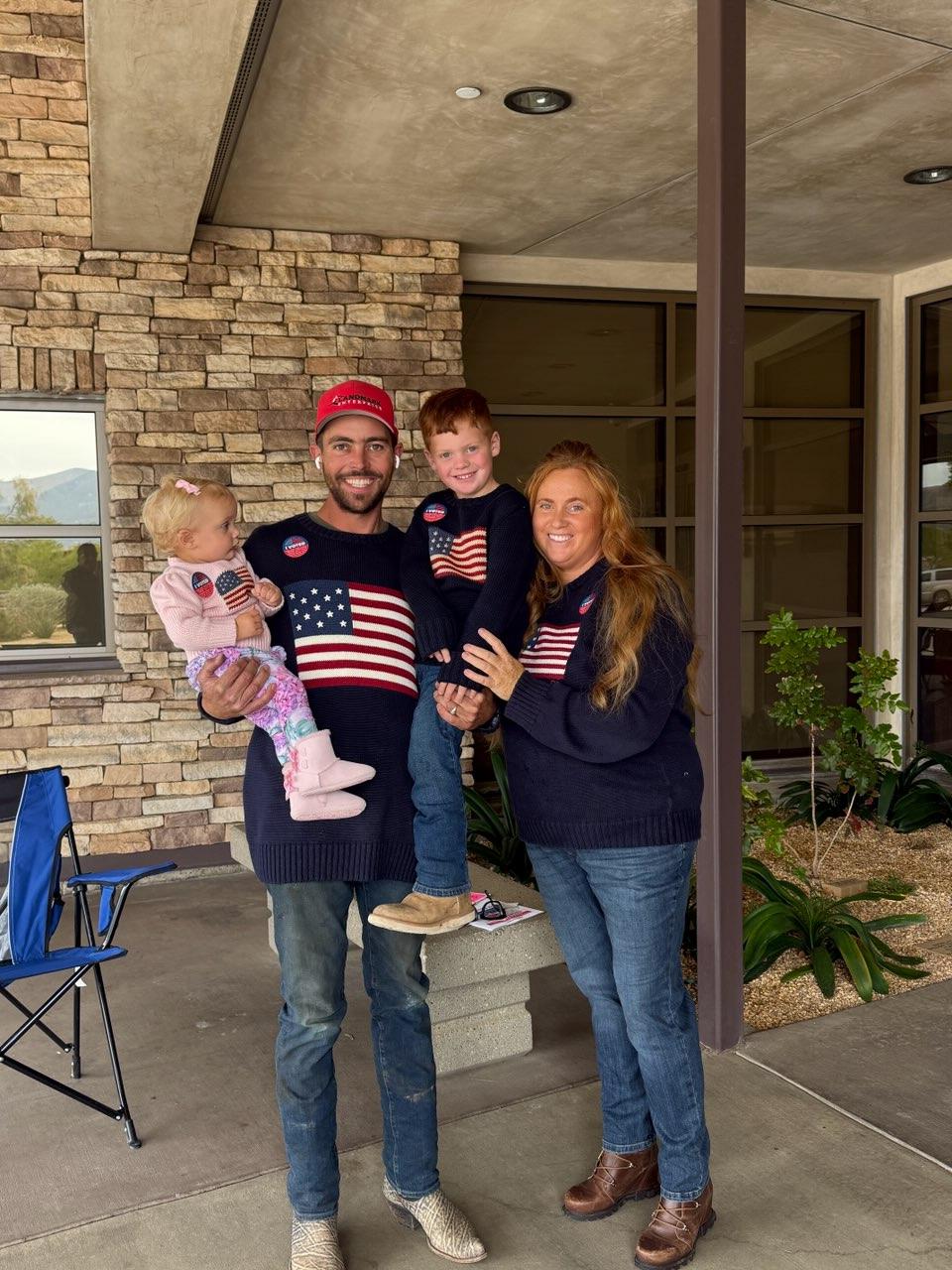 Riley Bowers and his family wearing American flag sweaters and I Voted stickers outside the polling place